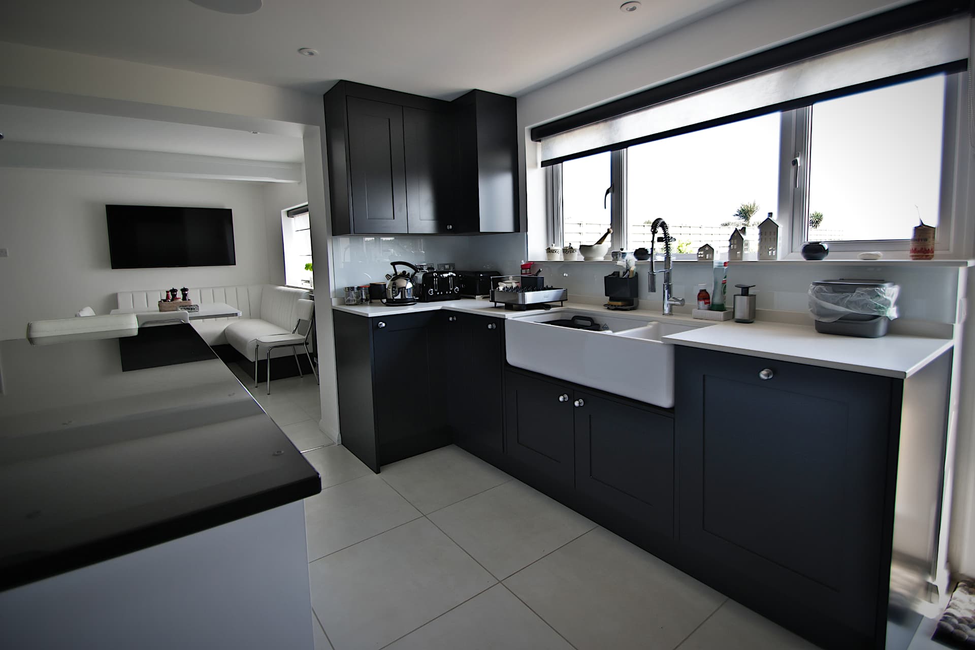 Dark navy shaker kitchen with white quartz worktops and ceramic butler sink