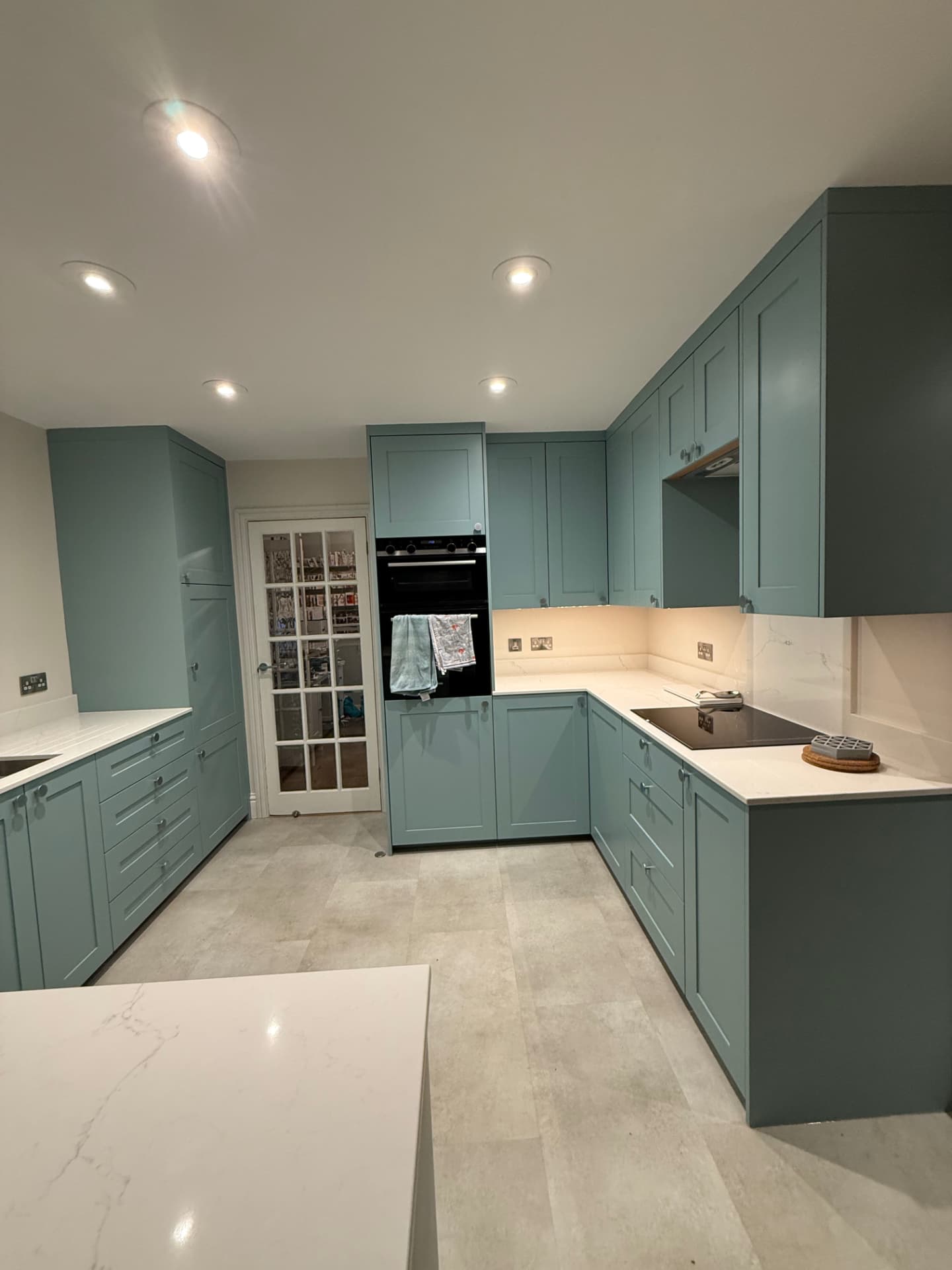 Teal shaker kitchen with quartz worktops, integrated appliances and walk-in pantry