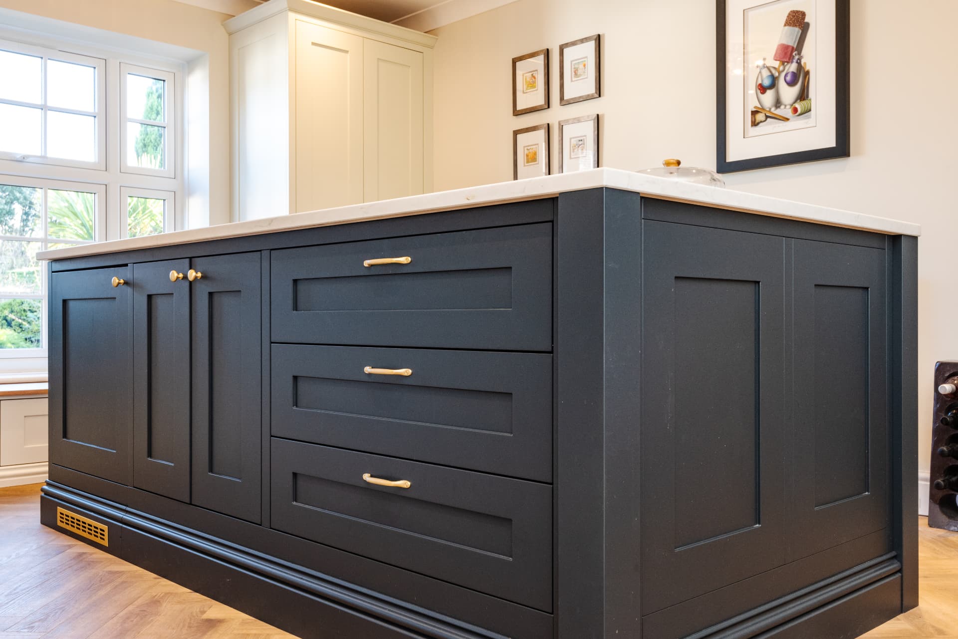 Bespoke dark painted kitchen island with brass handles and light quartz worktops